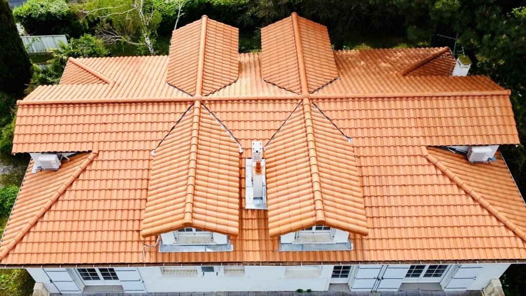 Vue aérienne finale de la toiture rénovée avec une partie de la façade de l'habitation après livraison du chantier.